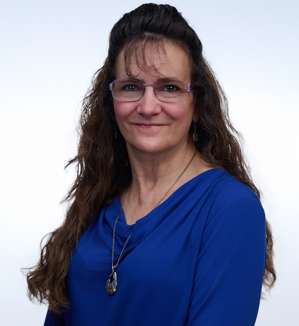 headshot of a woman in a blue shirt.